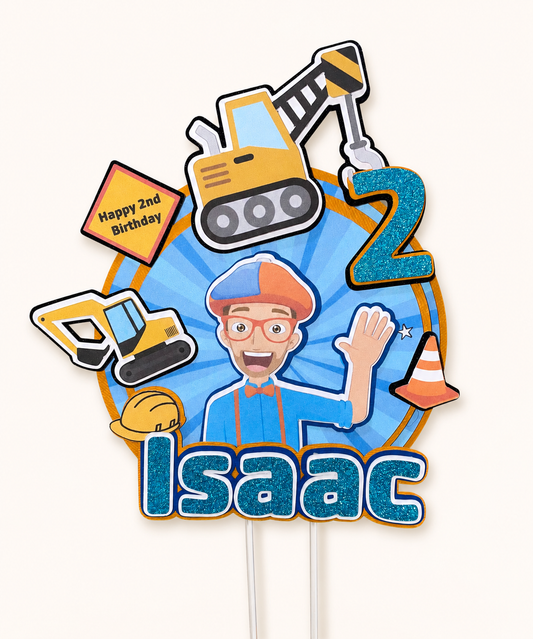 A personalised children's birthday cake, Blippi. Topper featuring a cartoon construction theme, with blue glitter-style lettering, a large number 2, and construction-themed icons including a yellow excavator, yellow sign reading 'Happy 2nd Birthday,' a hard hat, and a traffic cone on a light cream background.